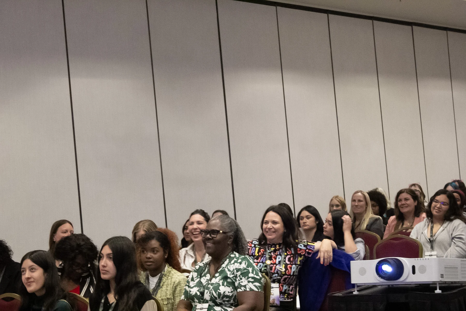 Conference audience smiling and laughing during a session