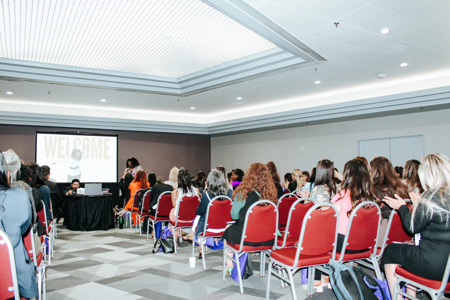 Irene Wilkins at the front of a conference room with an audience