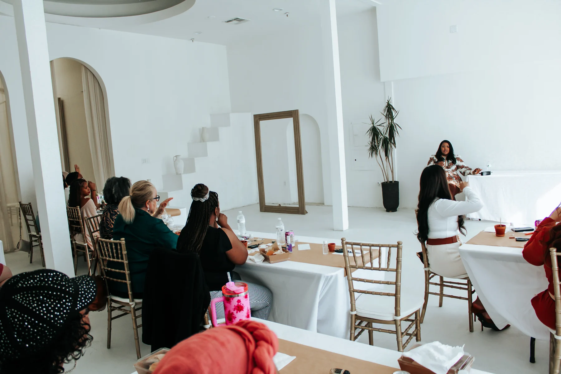 Irene Wilkins facilitating an interactive workshop with participants raising their hands